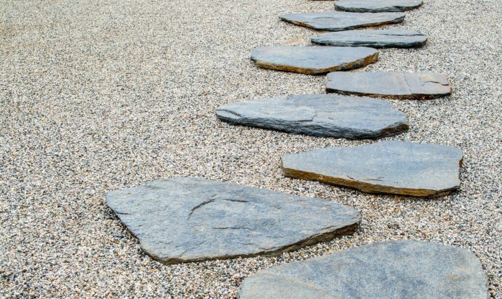 flat stepping stones atop a sandy gravel mix